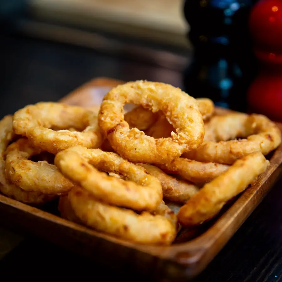 A wooden board of golden battered calamari rings